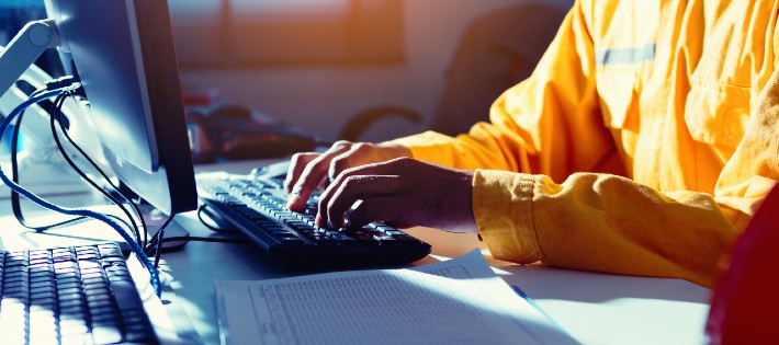 person in yellow working on laptop